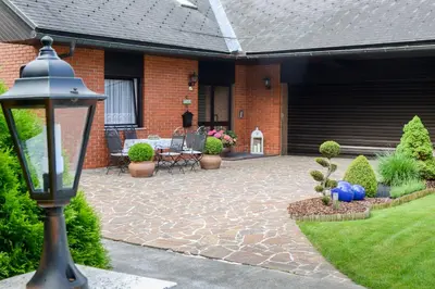 a patio of a house with a table and chairs at Guest House Bakhus in Žerjavka
