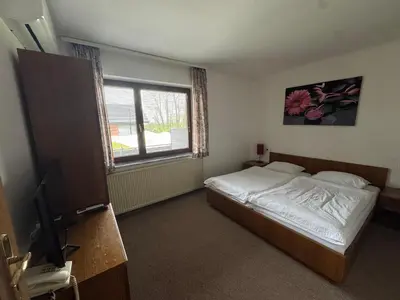 a bedroom with a bed and a window at Guest House Bakhus in Žerjavka