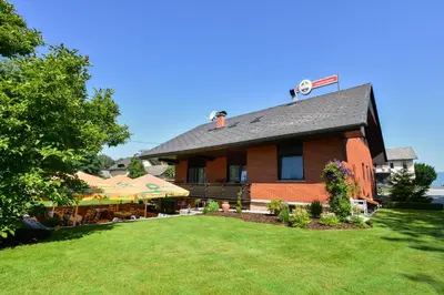a large brick building with a lawn in front of it at Guest House Bakhus in Žerjavka