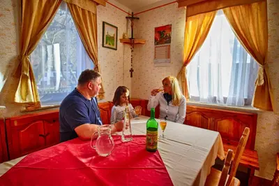 a group of people sitting at a table in a restaurant at Pri Lazarju Farm Stay in Podgrad