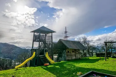 a playground with a slide in front of a building at Pri Lazarju Farm Stay in Podgrad