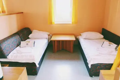a small room with two beds and a table at Terme Olimia - Apartment Village Lipa in Podčetrtek