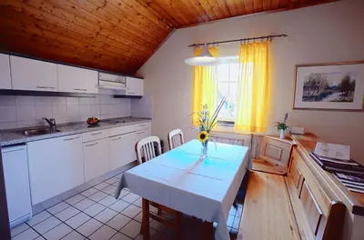 a kitchen with a table and a table and chairs at Terme Olimia - Apartment Village Lipa in Podčetrtek