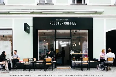 people sitting at tables outside of a coffee shop at NA Apartments in Maribor