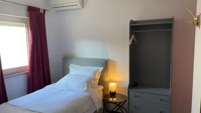 a bedroom with a bed and a dresser and a window at MADONCA ROOMS & RESTAURANT in Nova Gorica