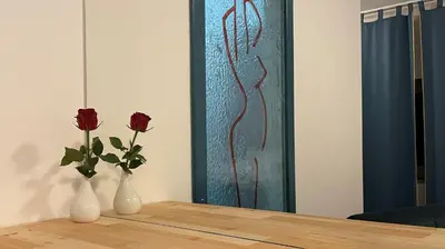 two vases with roses in them on a table at MADONCA ROOMS & RESTAURANT in Nova Gorica