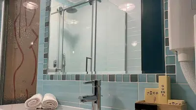 a bathroom with a mirror and a sink with towels at MADONCA ROOMS & RESTAURANT in Nova Gorica