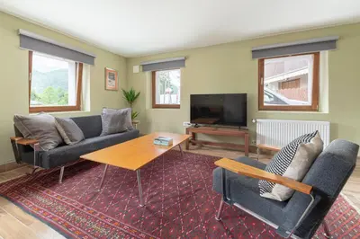 a living room with two couches and a tv at Farmhouse Chalet Apartments in Bohinjska Bistrica