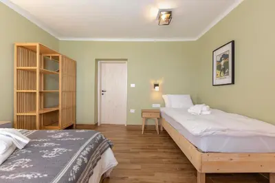 a bedroom with two beds and a book shelf at Farmhouse Chalet Apartments in Bohinjska Bistrica