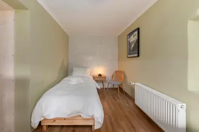 a bedroom with a bed and a table with a lamp at Farmhouse Chalet Apartments in Bohinjska Bistrica