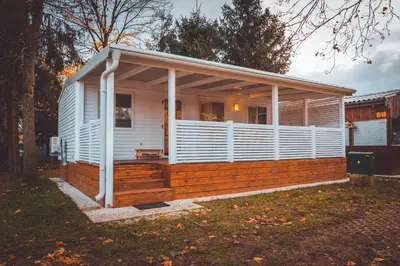 a small white house with a large deck at Holiday cottage with 2 Thermal Riviera Tickets in Moravske Toplice