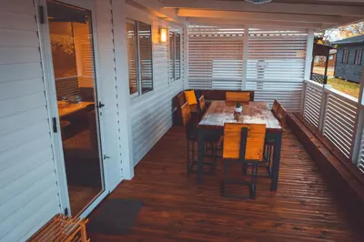 a porch with a table and chairs on a deck at Holiday cottage with 2 Thermal Riviera Tickets in Moravske Toplice