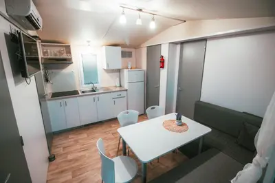 a small kitchen with a white table and chairs at Holiday cottage with 2 Thermal Riviera Tickets in Moravske Toplice