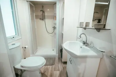 a white bathroom with a toilet and a sink at Holiday cottage with 2 Thermal Riviera Tickets in Moravske Toplice