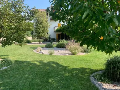 a garden with green grass and a house at House Wisteria in Kostanjevica na Krasu