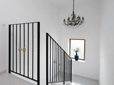a staircase with a chandelier and a mirror at House Wisteria in Kostanjevica na Krasu
