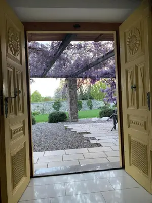 an open door with a view of a garden at House Wisteria in Kostanjevica na Krasu