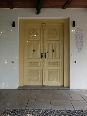 a pair of wooden doors on a building at House Wisteria in Kostanjevica na Krasu