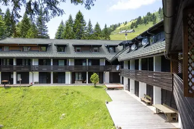 an exterior view of a building with a yard at Apartma Krvavec - cosy mountain retreat in Cerklje na Gorenjskem