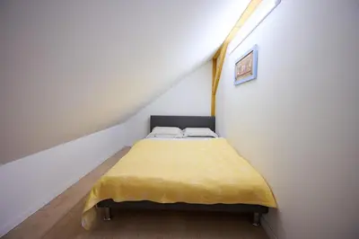 a small bedroom with a yellow bed in a attic at Apartment P42 in Slovenj Gradec