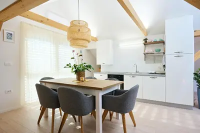 a kitchen with a wooden table and chairs at Apartment P42 in Slovenj Gradec