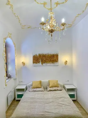 a bedroom with a large bed and a chandelier at Ljubljana City Center Apartment in Ljubljana