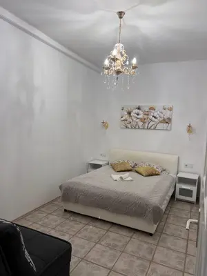 a bedroom with a bed and a chandelier at Ljubljana City Center Apartment in Ljubljana