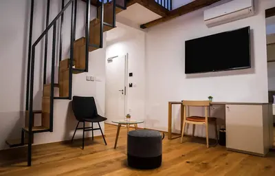 a living room with a tv and a table and chairs at Hotel Belmur in Murska Sobota