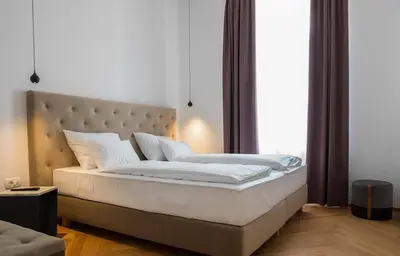 a bedroom with a large white bed with a large window at Hotel Belmur in Murska Sobota