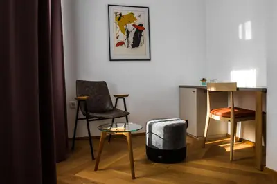 a living room with two chairs and a table at Hotel Belmur in Murska Sobota