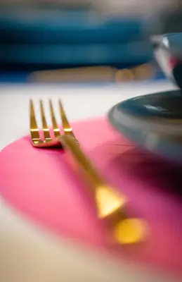 a fork sitting on top of a pink plate at Apartment VAZATAOR with sauna in Brežice