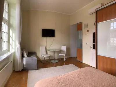 a bedroom with a bed and a table and chairs at Apartment 19 Vila Golf Nice Vacation in Rogaška Slatina