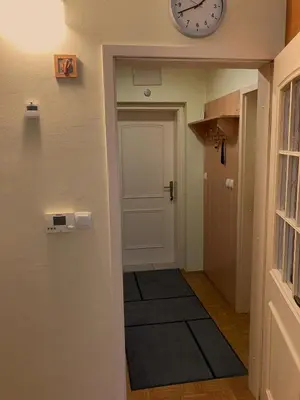 a hallway with a door and a clock on the wall at Apartment 19 Vila Golf Nice Vacation in Rogaška Slatina