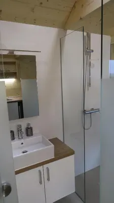 a white bathroom with a sink and a shower at Apartma, glamping Na koncu vasi in Ljutomer