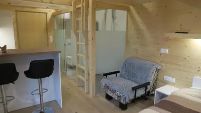 a bedroom with a bed and a desk and chairs at Apartma, glamping Na koncu vasi in Ljutomer