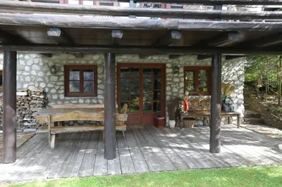 a porch of a cabin with a table and a bench at Mountain Dreams House - Stunning view over Lake Jasna! in Kranjska Gora