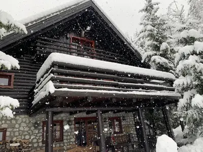 a snow covered roof of a log cabin at Mountain Dreams House - Stunning view over Lake Jasna! in Kranjska Gora