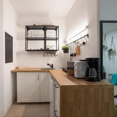 a kitchen with white cabinets and a counter with a microwave at APARTMENT SAPICA in Solkan