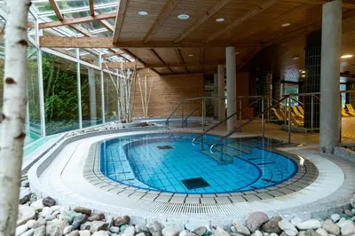 a large swimming pool in a building with a building at Hotel Toplice - Terme Krka in Smarjeske Toplice