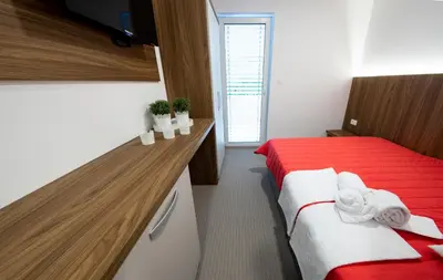 a bedroom with a red bed and a wooden counter at Gostilna Pugelj in Novo Mesto