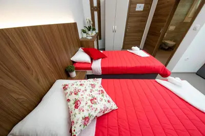 two beds in a room with red and white blankets at Gostilna Pugelj in Novo Mesto