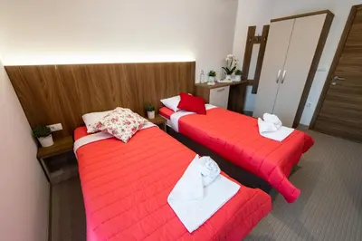 a hotel room with two beds with red sheets at Gostilna Pugelj in Novo Mesto