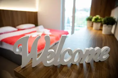 a bedroom with a bed with a red blanket and a wooden floor at Gostilna Pugelj in Novo Mesto