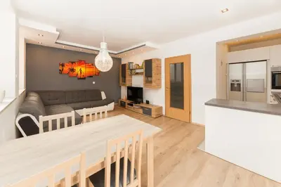 a kitchen and living room with a couch and a table at Apartma Jelendol in Tržič