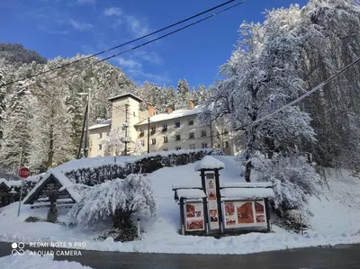 a building covered in snow with a sign in front of it at Apartma Jelendol in Tržič