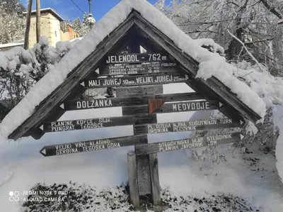 a wooden sign covered in snow with snow on it at Apartma Jelendol in Tržič