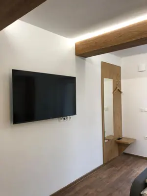 a flat screen tv on a wall in a room at Maximo Apartments - free parking in Maribor