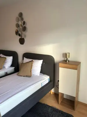 a small bedroom with a bed and a night stand at Maximo Apartments - free parking in Maribor