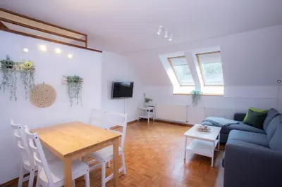 a living room with a blue couch and a table at Duplex Apartment Panj Kranjska Gora in Kranjska Gora