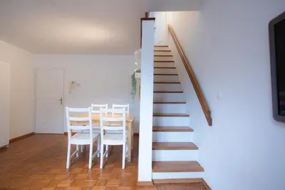 a staircase in a room with a table and chairs at Duplex Apartment Panj Kranjska Gora in Kranjska Gora
